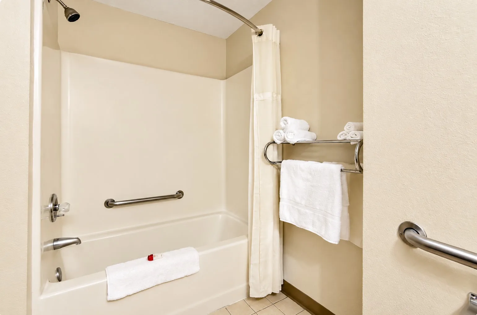 Tub and shower with grab bars and fresh towels